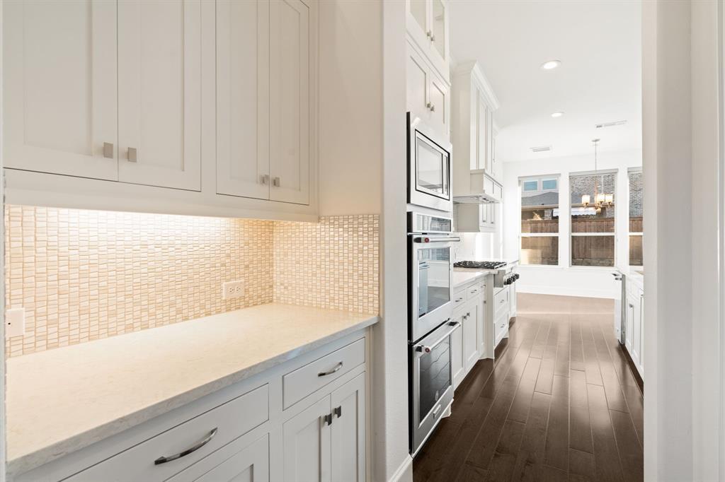 2441 Flat Creek Road Frisco, TX 75036 - Photo 11 of 34 Kitchen with white cabinets, tasteful backsplash, recessed lighting, appliances with stainless steel finishes, and decorative light fixtures
