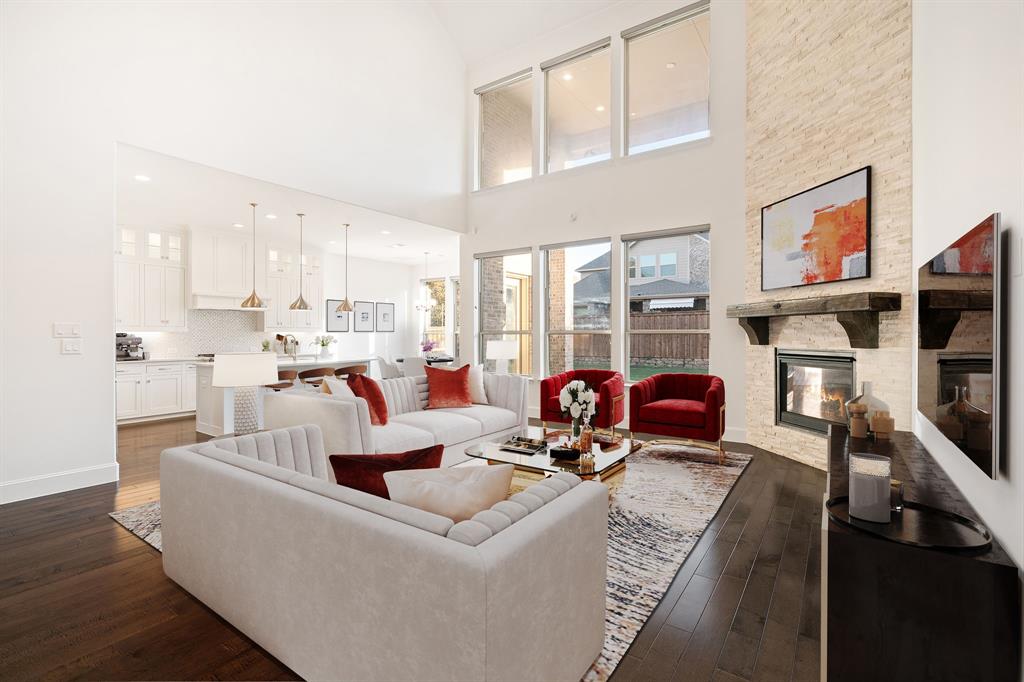 2441 Flat Creek Road Frisco, TX 75036 - Photo 4 of 34 Living room with dark wood finished floors, a fireplace, a high ceiling, and recessed lighting