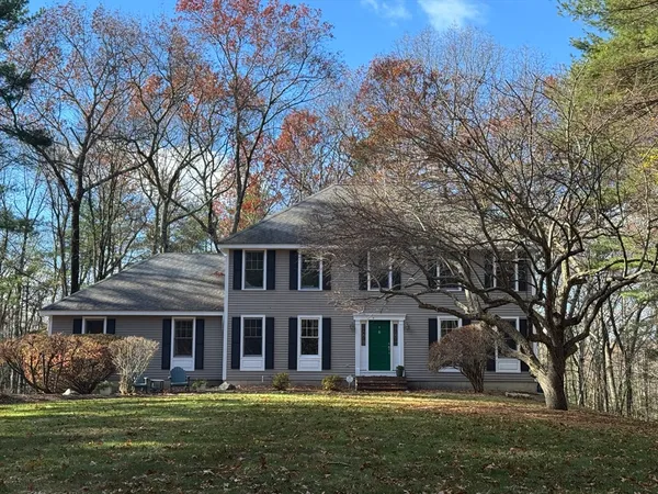 a front view of a house with a garden and trees