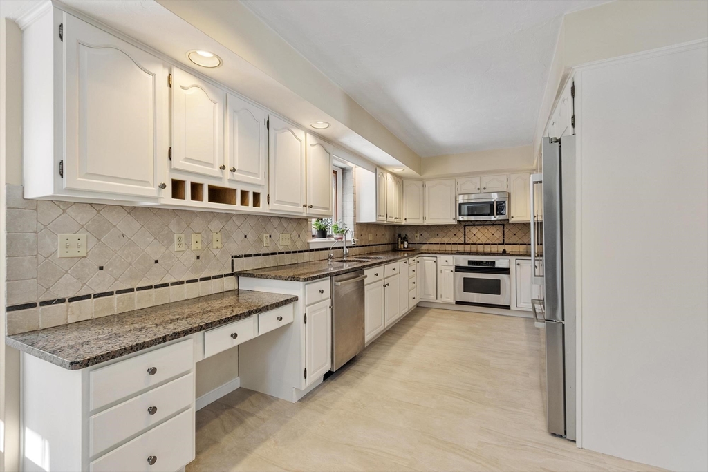 9 Blanchard Road Harvard, MA 01451 - Photo 6 of 33 a kitchen with granite countertop white cabinets and white appliances