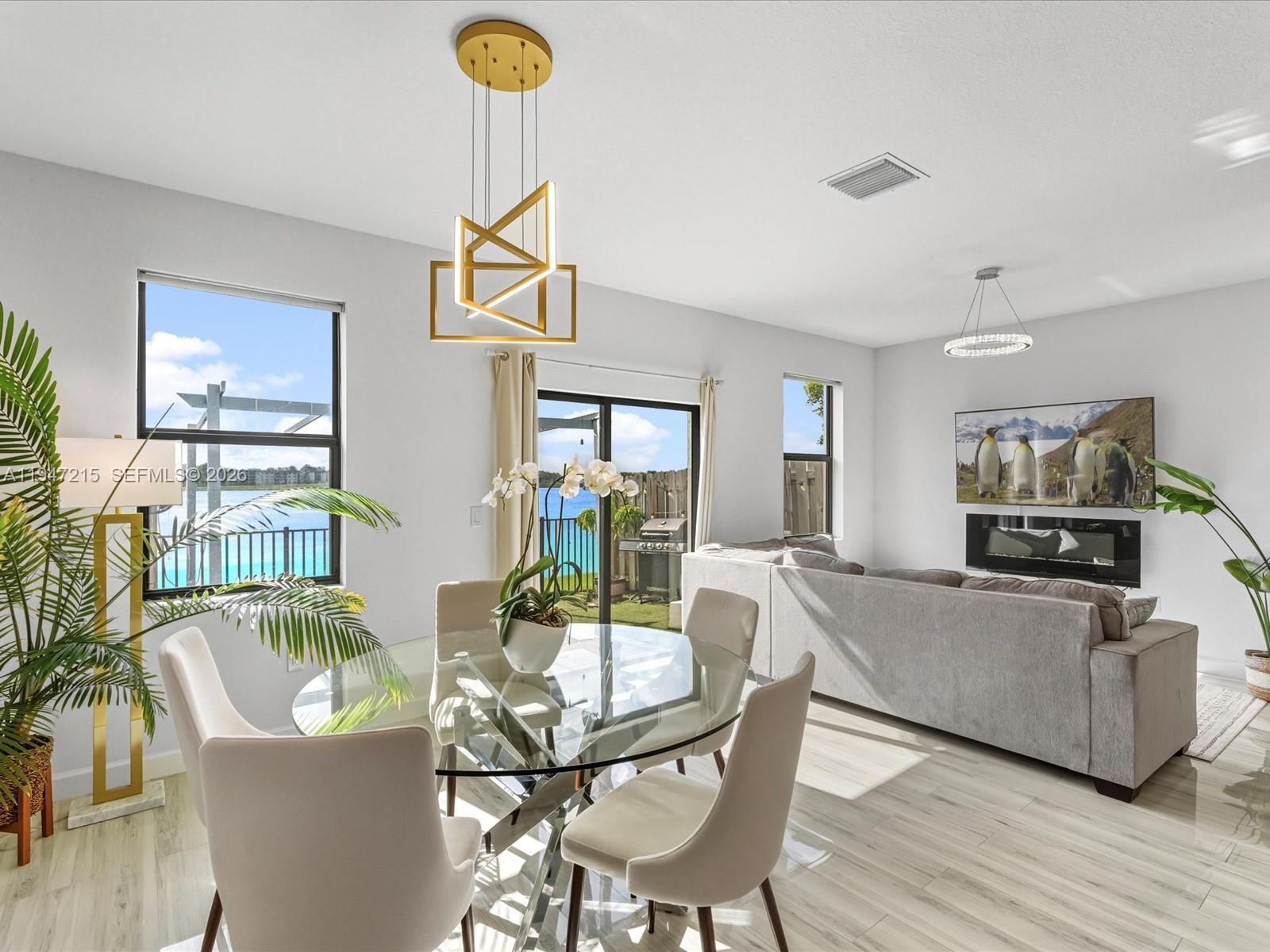 544 Northeast 206th Lane Miami, FL 33179 - Photo 11 of 48 a living room with furniture a chandelier and a wooden floor