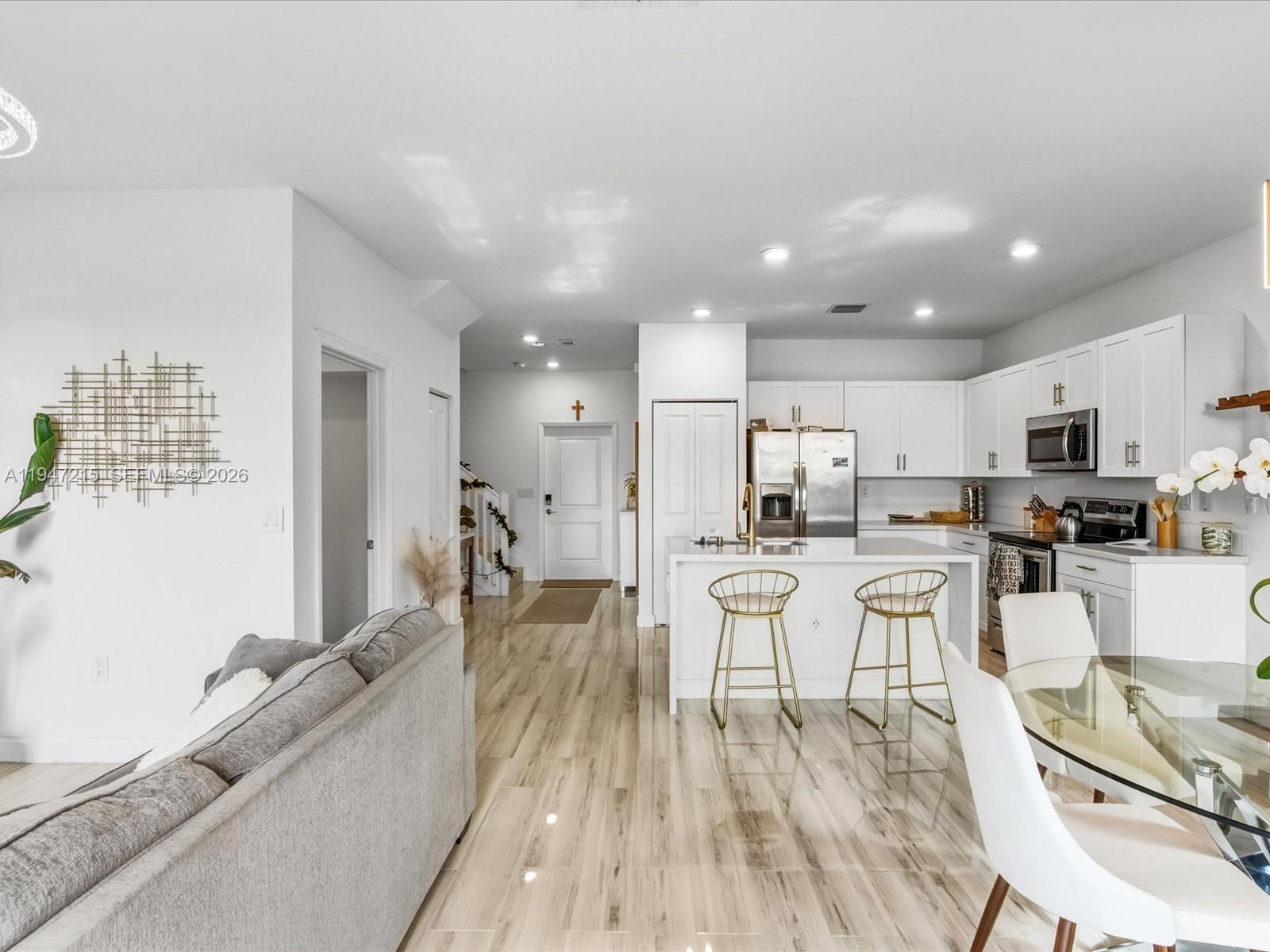 544 Northeast 206th Lane Miami, FL 33179 - Photo 15 of 48 a large dining hall with stainless steel appliances granite countertop a stove a sink a dining table and chairs with wooden floor