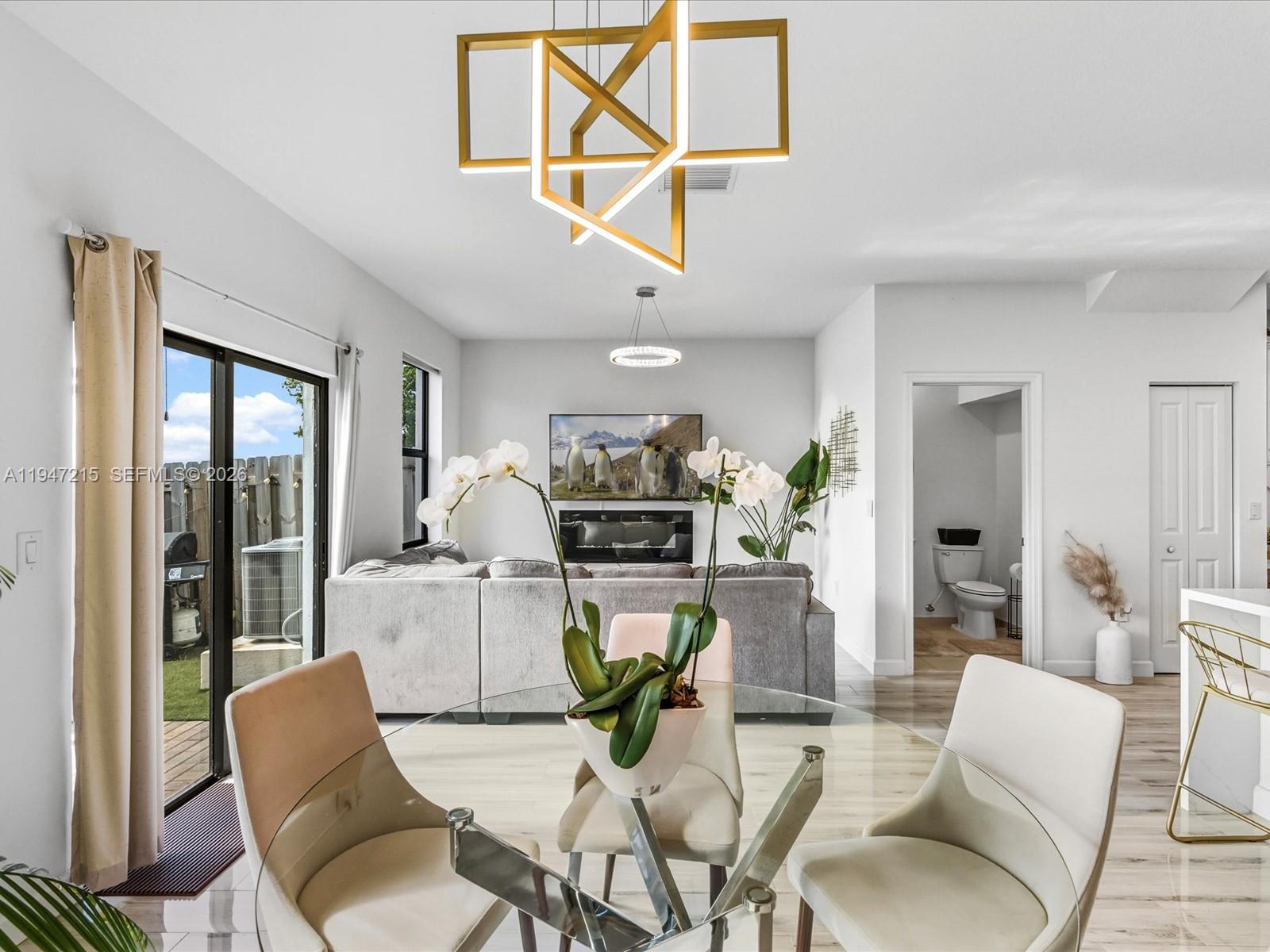 544 Northeast 206th Lane Miami, FL 33179 - Photo 16 of 48 a view of a dining room with furniture a kitchen and chandelier