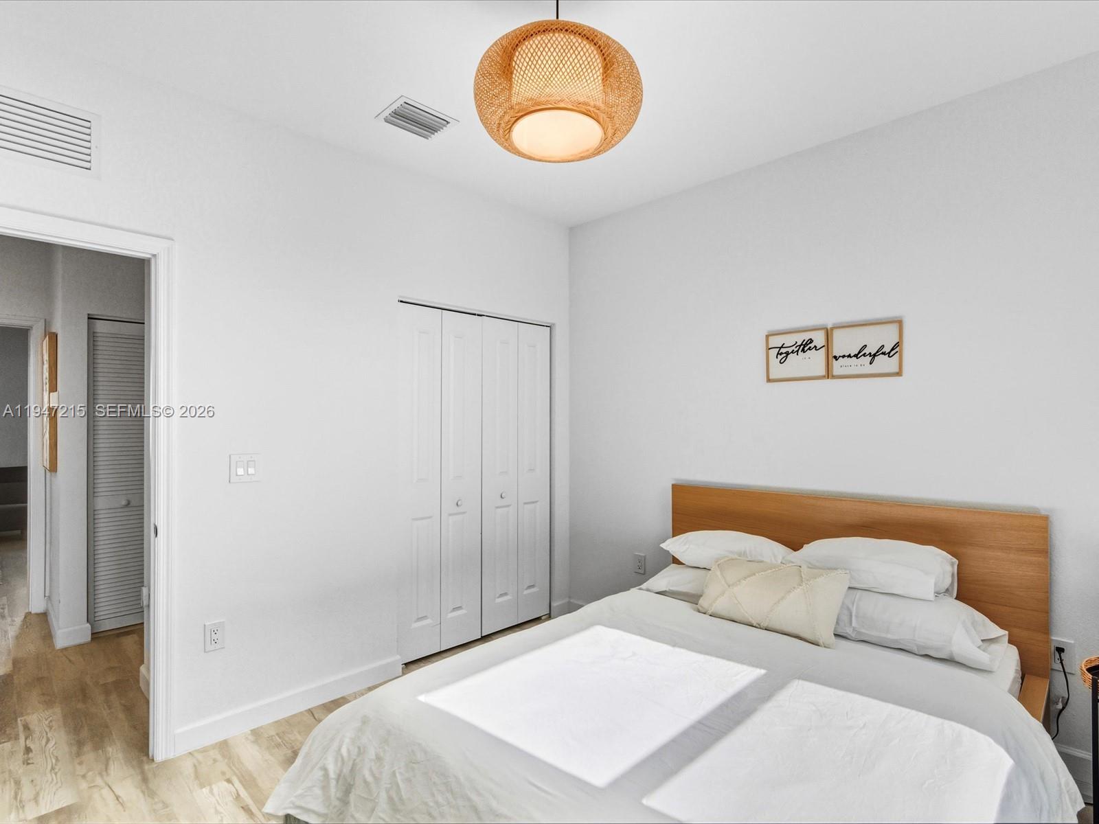 544 Northeast 206th Lane Miami, FL 33179 - Photo 26 of 48 a bedroom with a bed and a lamp