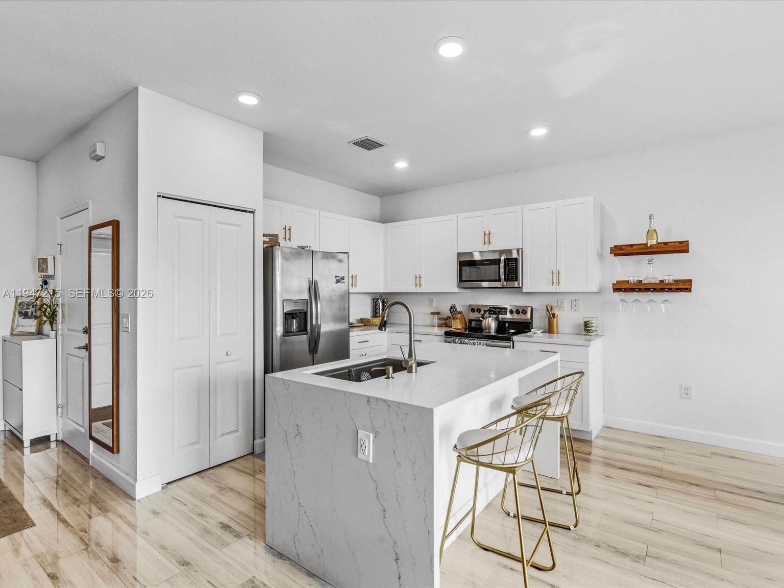 544 Northeast 206th Lane Miami, FL 33179 - Photo 8 of 48 a kitchen with stainless steel appliances a refrigerator stove microwave and cabinets