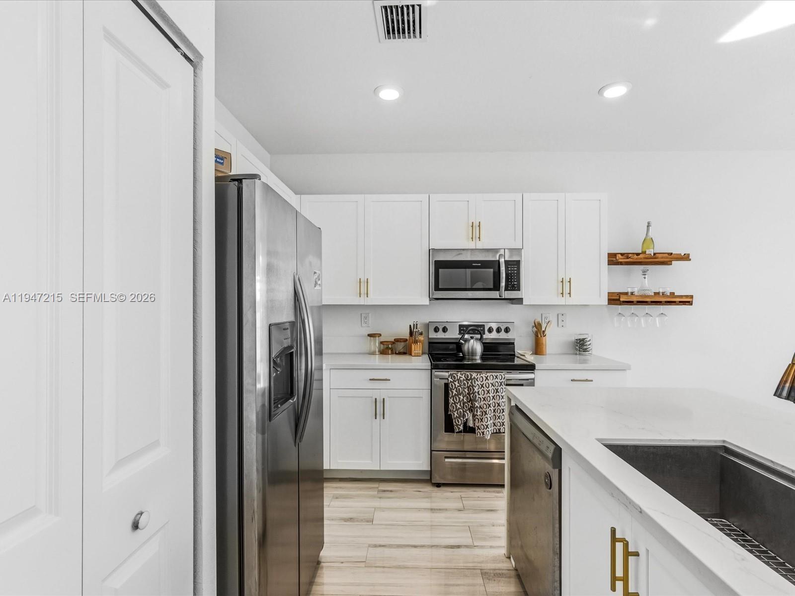 544 Northeast 206th Lane Miami, FL 33179 - Photo 9 of 48 a kitchen with cabinets stainless steel appliances and a sink