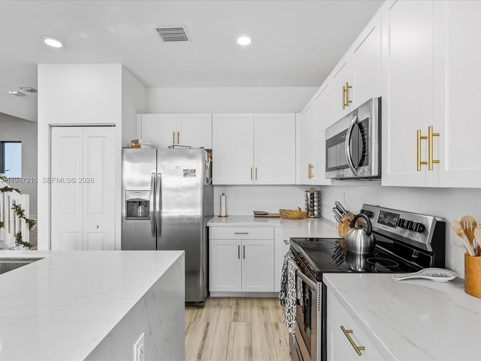 544 Northeast 206th Lane Miami, FL 33179 - Photo 10 of 48 a kitchen with stainless steel appliances a refrigerator sink and microwave