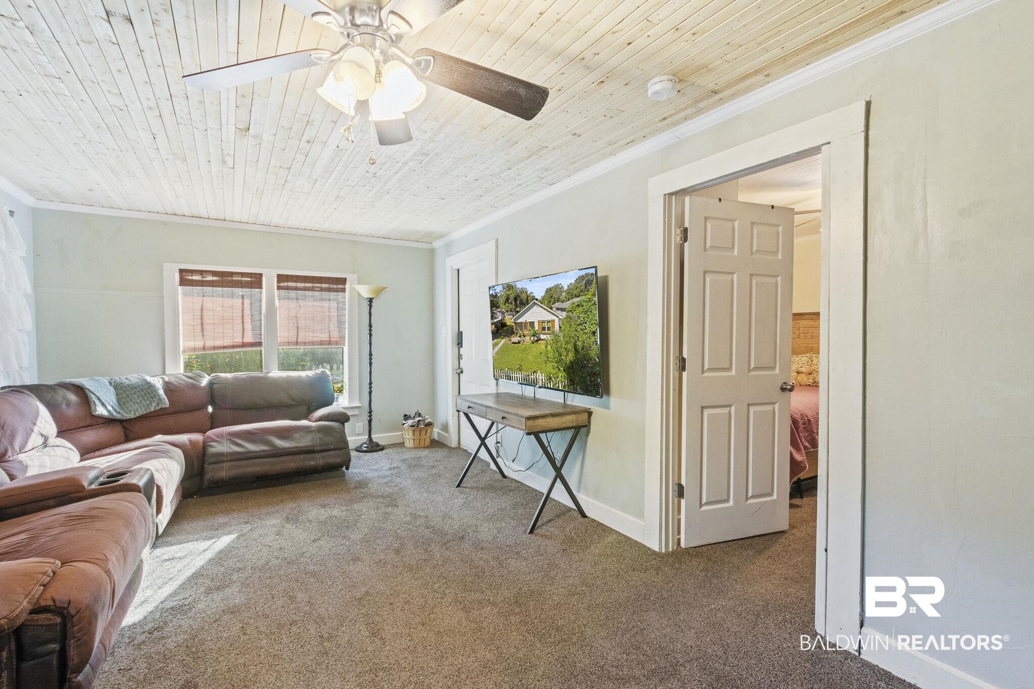 707 North Cedar Street Foley, AL 36535 - Photo 8 of 69 Carpeted living room featuring ceiling fan, wood ceiling, and crown molding