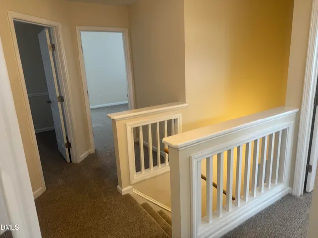 a view of staircase with white walls and a window
