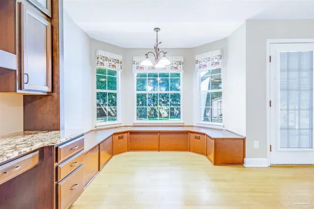 a large white kitchen with granite countertop a large window