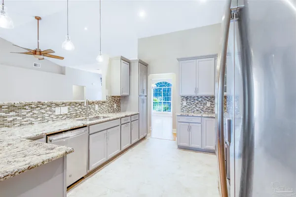 a bathroom with a granite countertop sink a toilet a shower and mirror