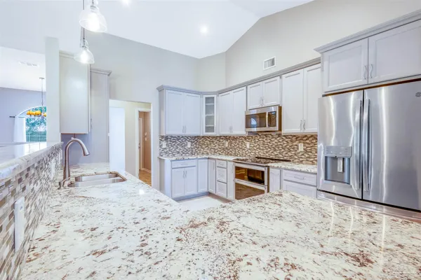 a kitchen with stainless steel appliances granite countertop a stove refrigerator and microwave