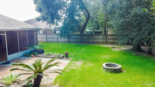 a view of a backyard with table and chairs and wooden fence