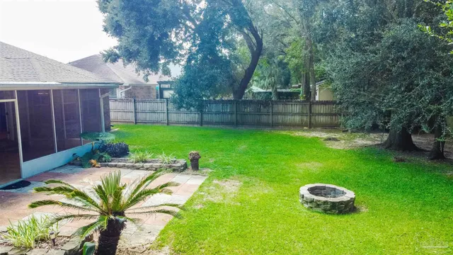 a view of a backyard with table and chairs and wooden fence