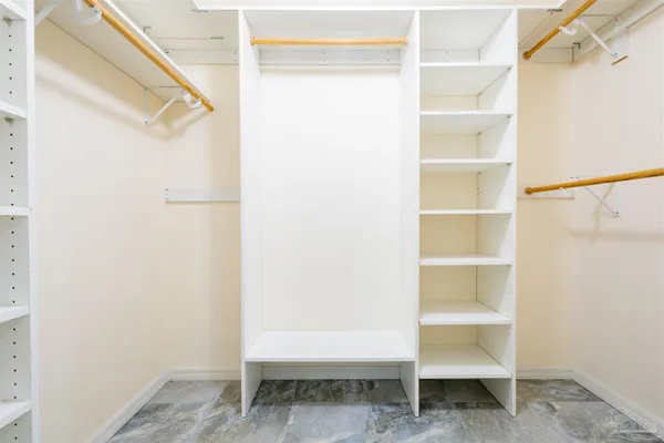 a view of walk in closet with empty racks