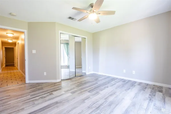 an empty room with wooden floor and door