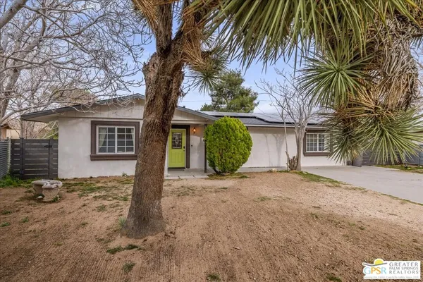 a view of a house with a tree in front of it