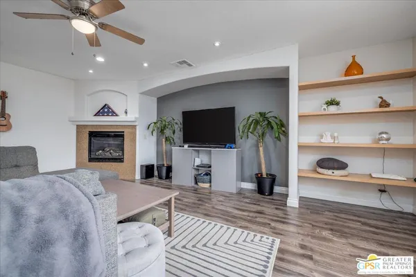 a living room with furniture a flat screen tv and a fireplace