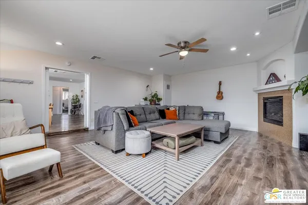 a living room with furniture a fireplace and wooden floor