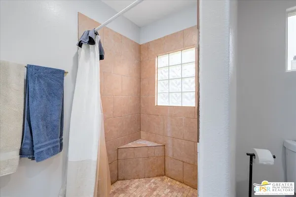 a bathroom with a toilet and a shower