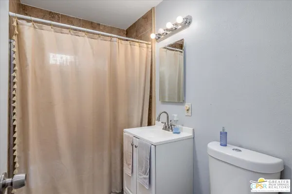 a bathroom with a sink a toilet and shower curtain