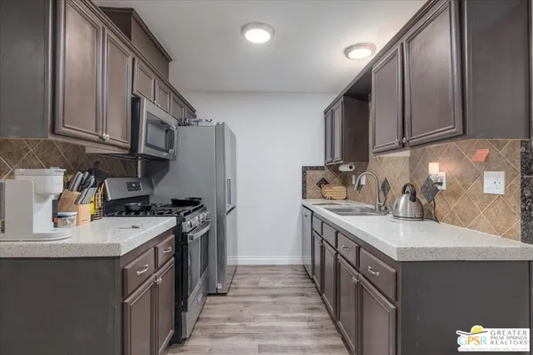 a kitchen with a sink stove top oven and cabinets