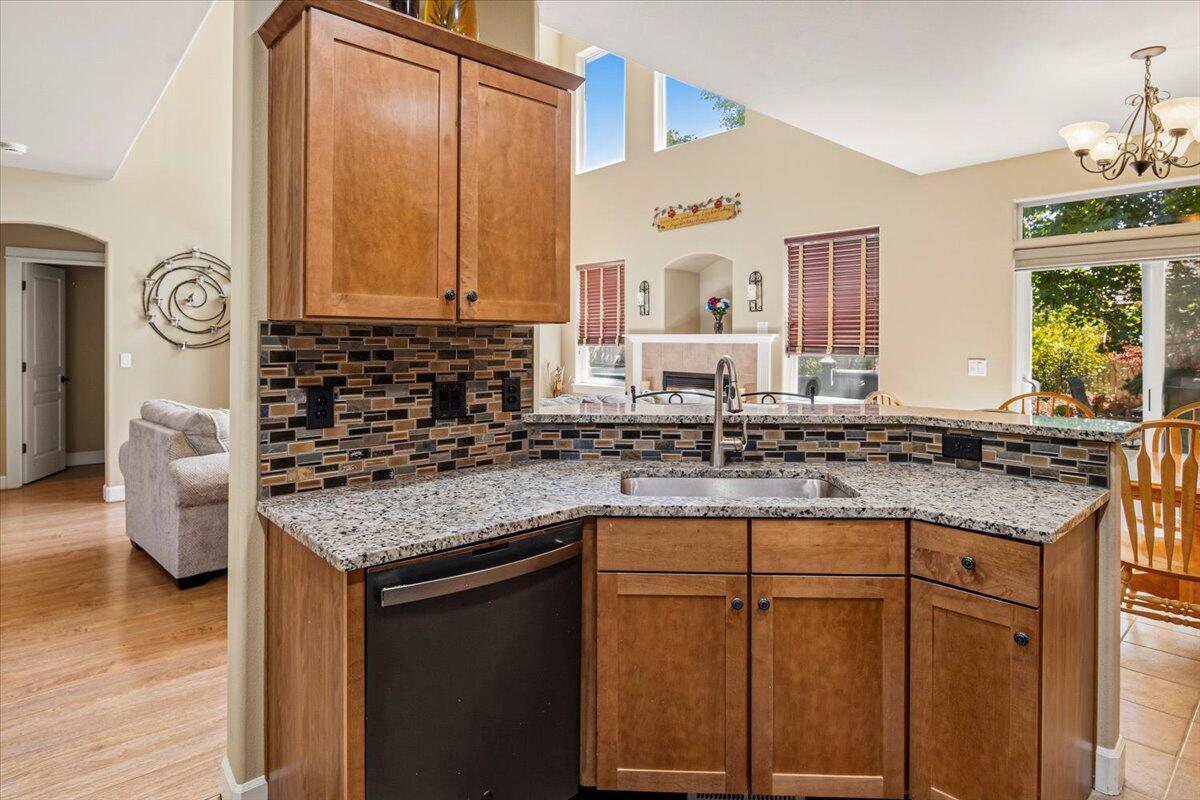 1339 Southwest Rimrock Way Redmond, OR 97756 - Photo 7 of 26 a kitchen with stainless steel appliances granite countertop a sink and a stove