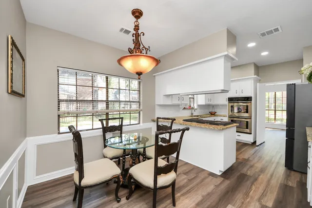 a view of a dining room with furniture wooden floor and chandelier