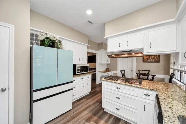 a kitchen with stainless steel appliances a refrigerator sink and cabinets