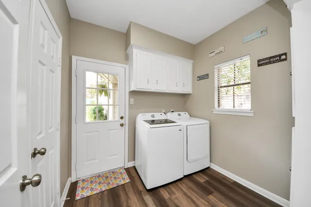 a utility room with wooden floor washer and dryer