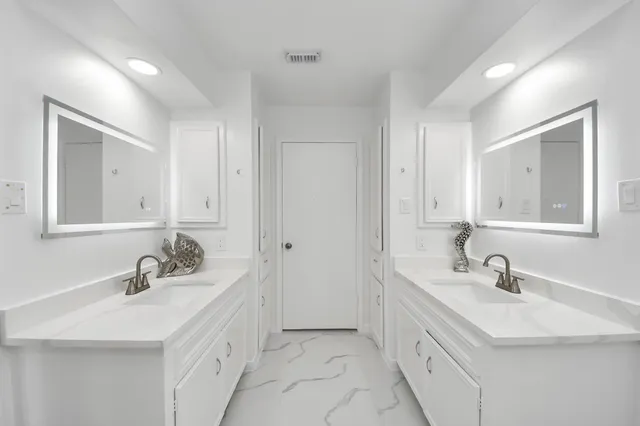 a bathroom with double sink and a mirror