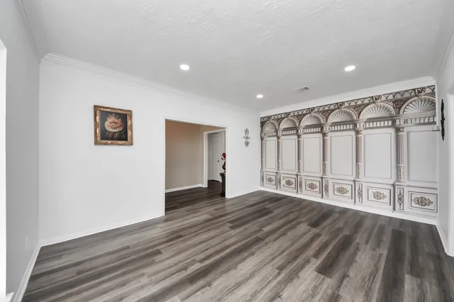 a view of an empty room with window and wooden floor