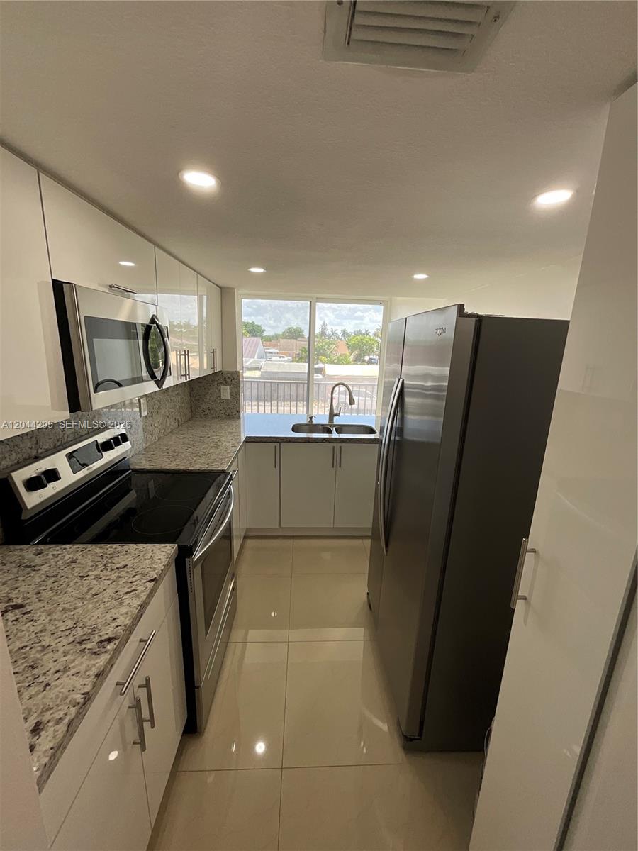 9441 Southwest 4th Street, Unit 214 Miami, FL 33174 - Photo 5 of 22 a kitchen with stainless steel appliances granite countertop a refrigerator a stove and a sink