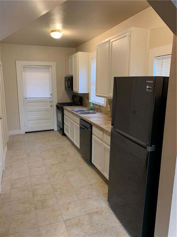 2714 Whitis Avenue, Unit ABC Austin, TX 78705 - Photo 3 of 24 Kitchen featuring black appliances, white cabinets, and decorative backsplash