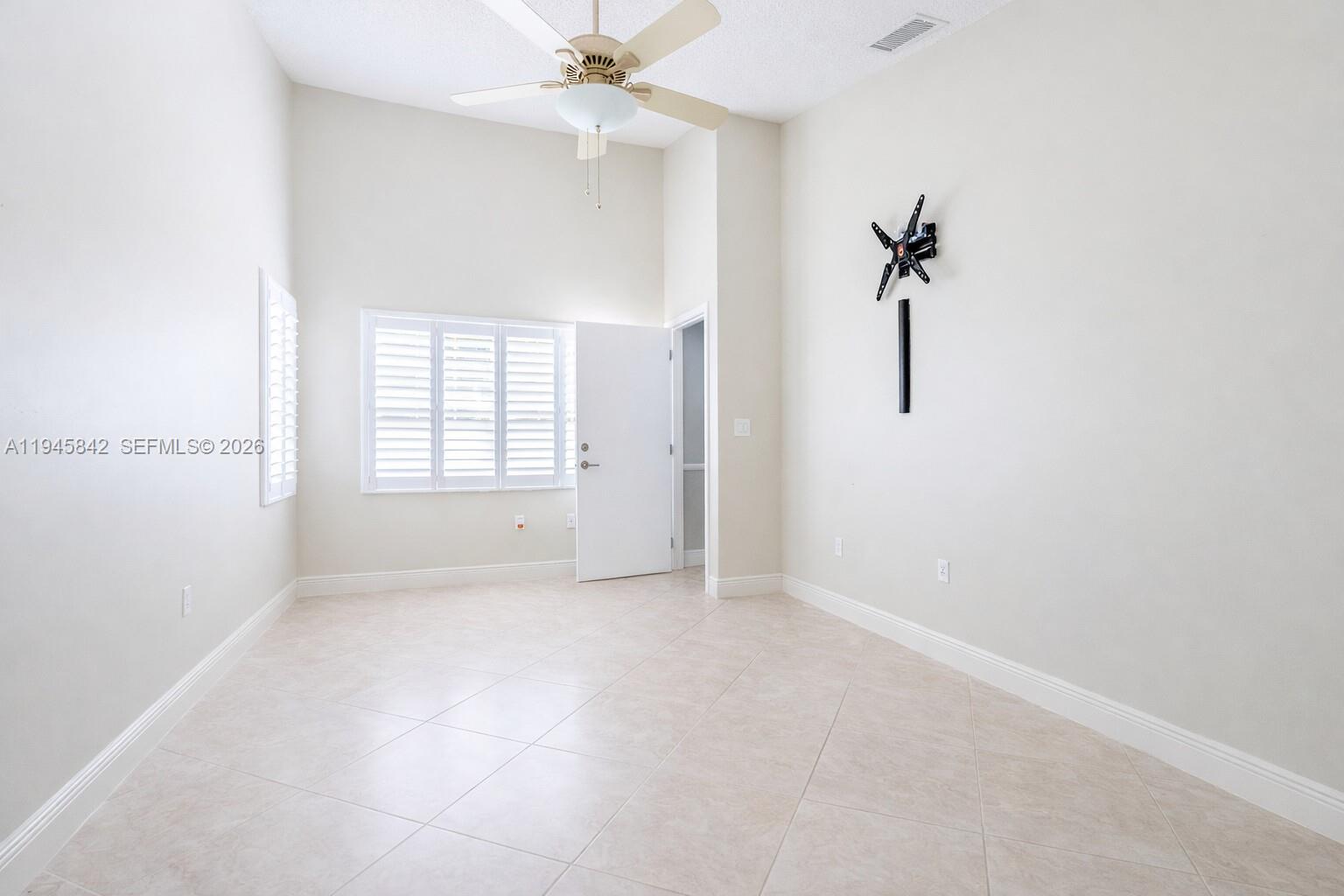 11291 Southwest 62nd Terrace Miami, FL 33173 - Photo 13 of 23 an empty room with a ceiling fan and a window