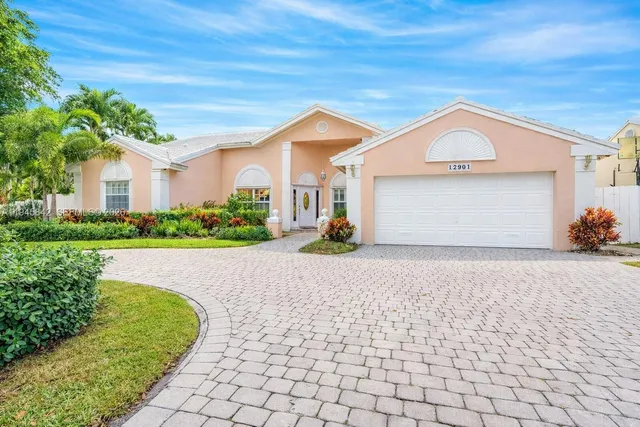 a view of a house with a yard and potted plants