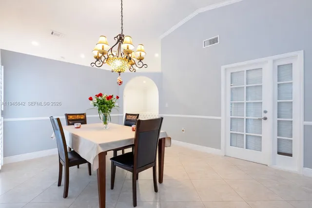 a view of a dining room with furniture and chandelier