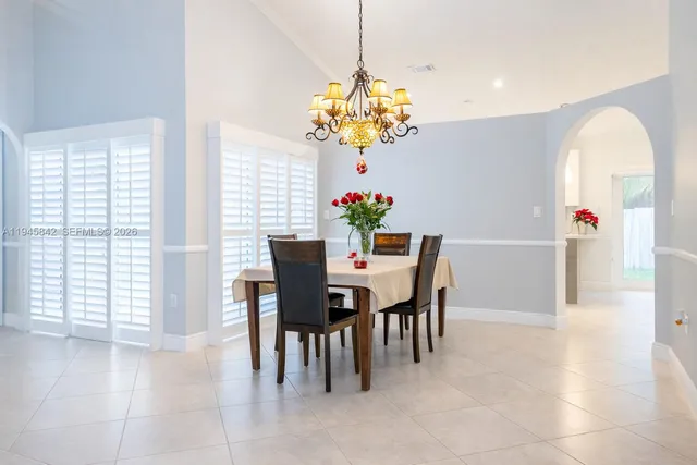a view of a dining room with furniture and a chandelier