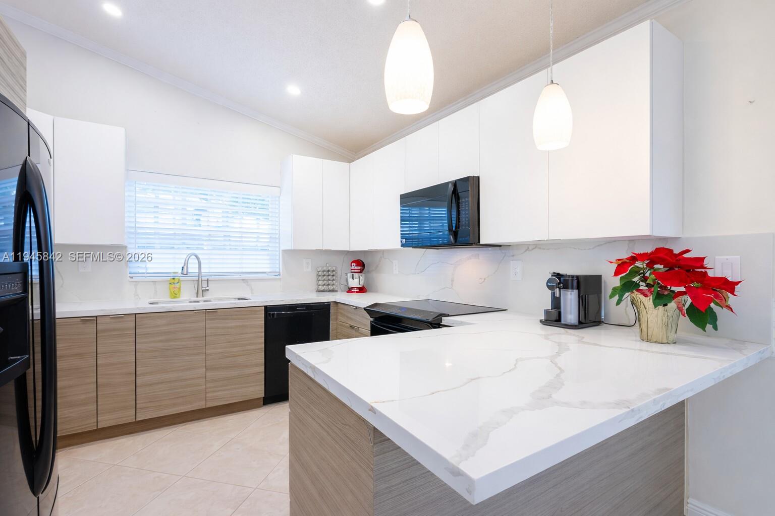 11291 Southwest 62nd Terrace Miami, FL 33173 - Photo 10 of 23 a kitchen with stainless steel appliances kitchen island granite countertop a sink a microwave and cabinets
