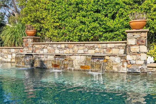 a swimming pool with plants and outdoor seating