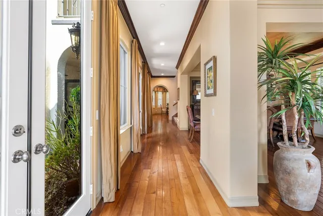 a view of a hallway with wooden floor and stairs