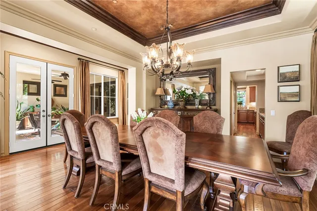 a dining room with furniture a chandelier and wooden floor
