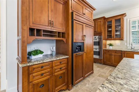 a kitchen with stainless steel appliances kitchen island granite countertop a refrigerator and cabinets