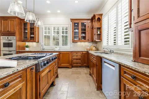a kitchen with stainless steel appliances granite countertop a stove and a sink