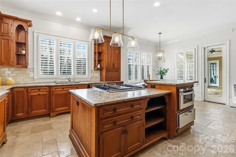 a kitchen with stainless steel appliances granite countertop a stove a sink and a refrigerator
