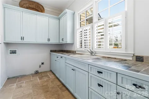 a kitchen with granite countertop white cabinets and a window