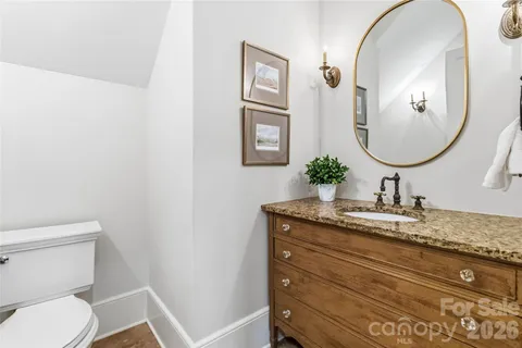 a bathroom with a granite countertop toilet sink and mirror