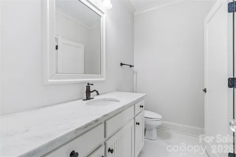 a bathroom with a granite countertop sink a toilet and a mirror