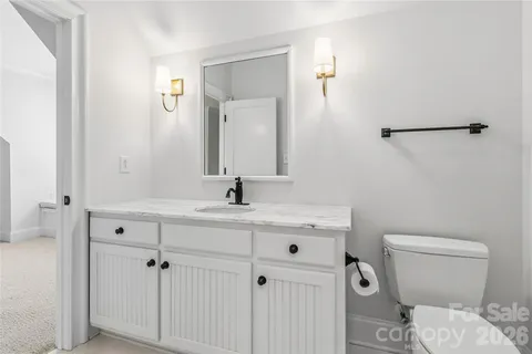 a bathroom with a toilet a sink and mirror