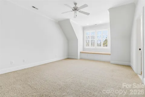 an empty room with windows and ceiling fan